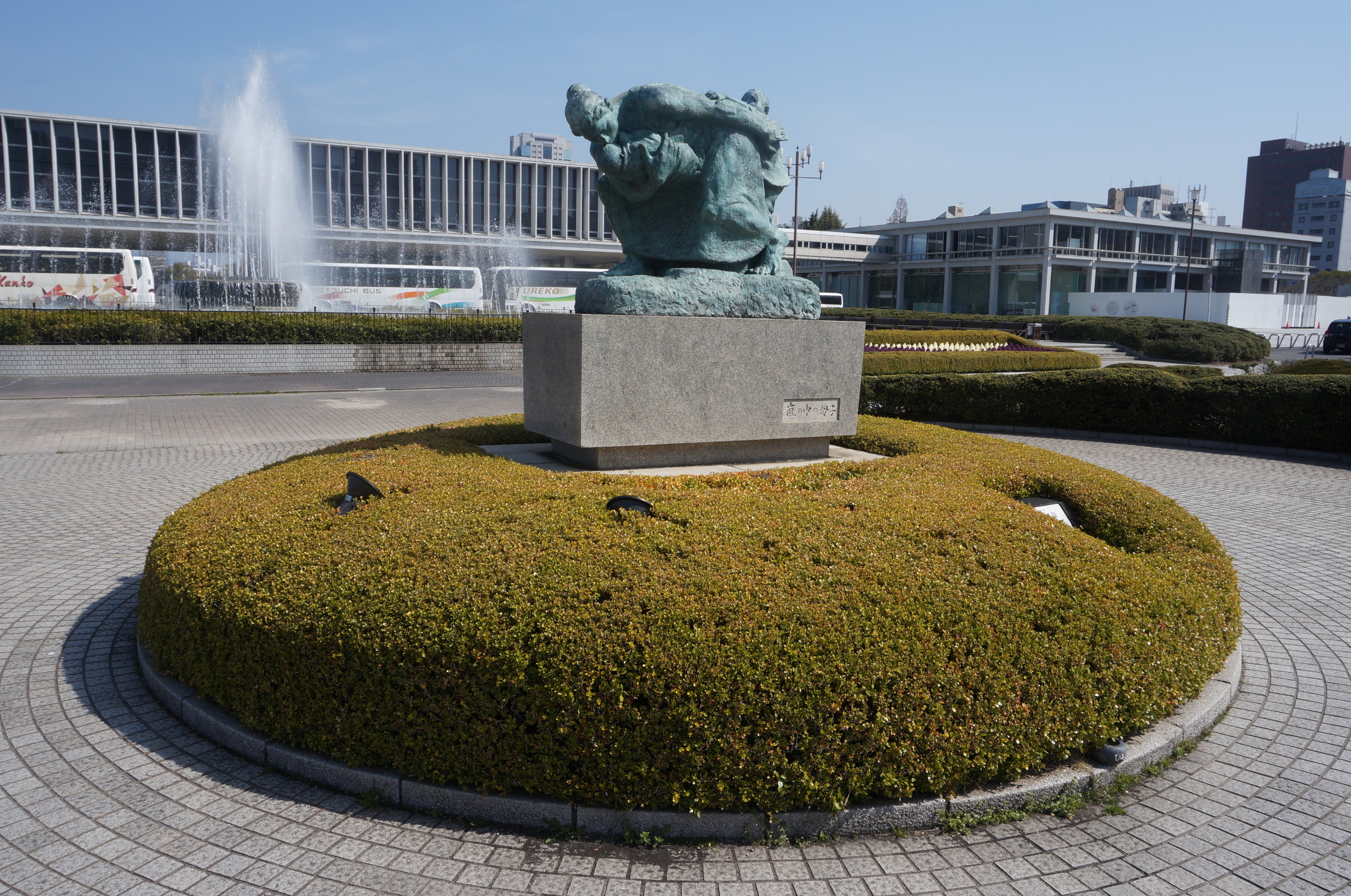 Statue auf einem Platz in der Nähe des Friedensparks. Hinten ist ein Teil des Atomic Bomb Museums zu sehen.